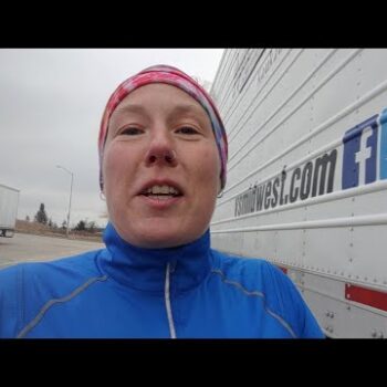 Female truck driver in jogging attire running around a truck